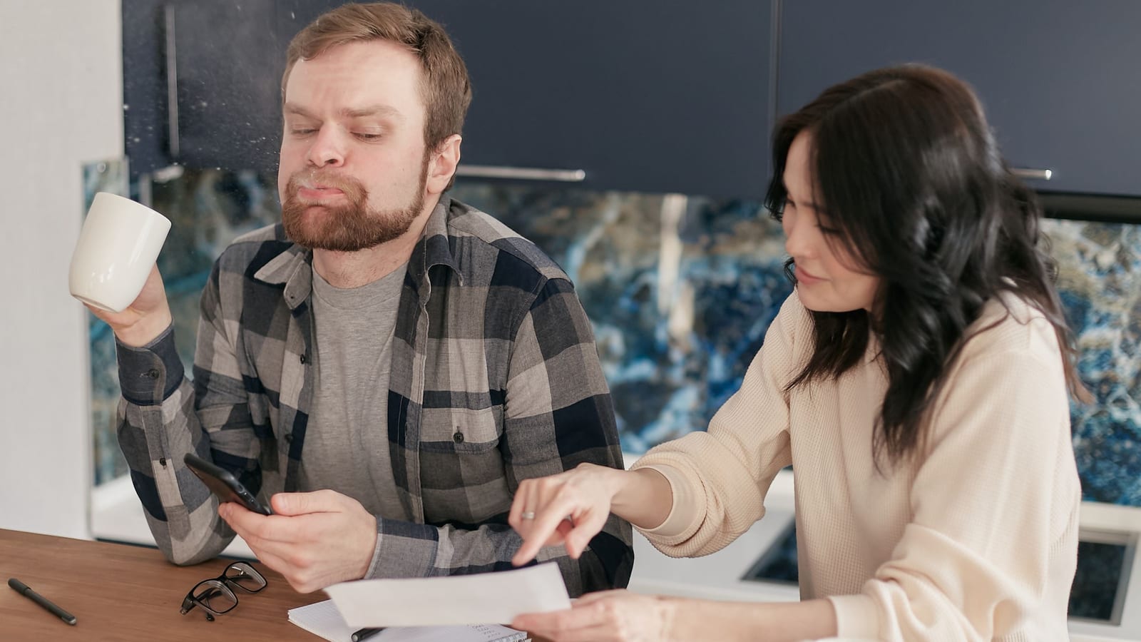 Florida couple at their kitchen table reviewing Marketplace health insurance premiums ahead of the 2027 Open Enrollment window