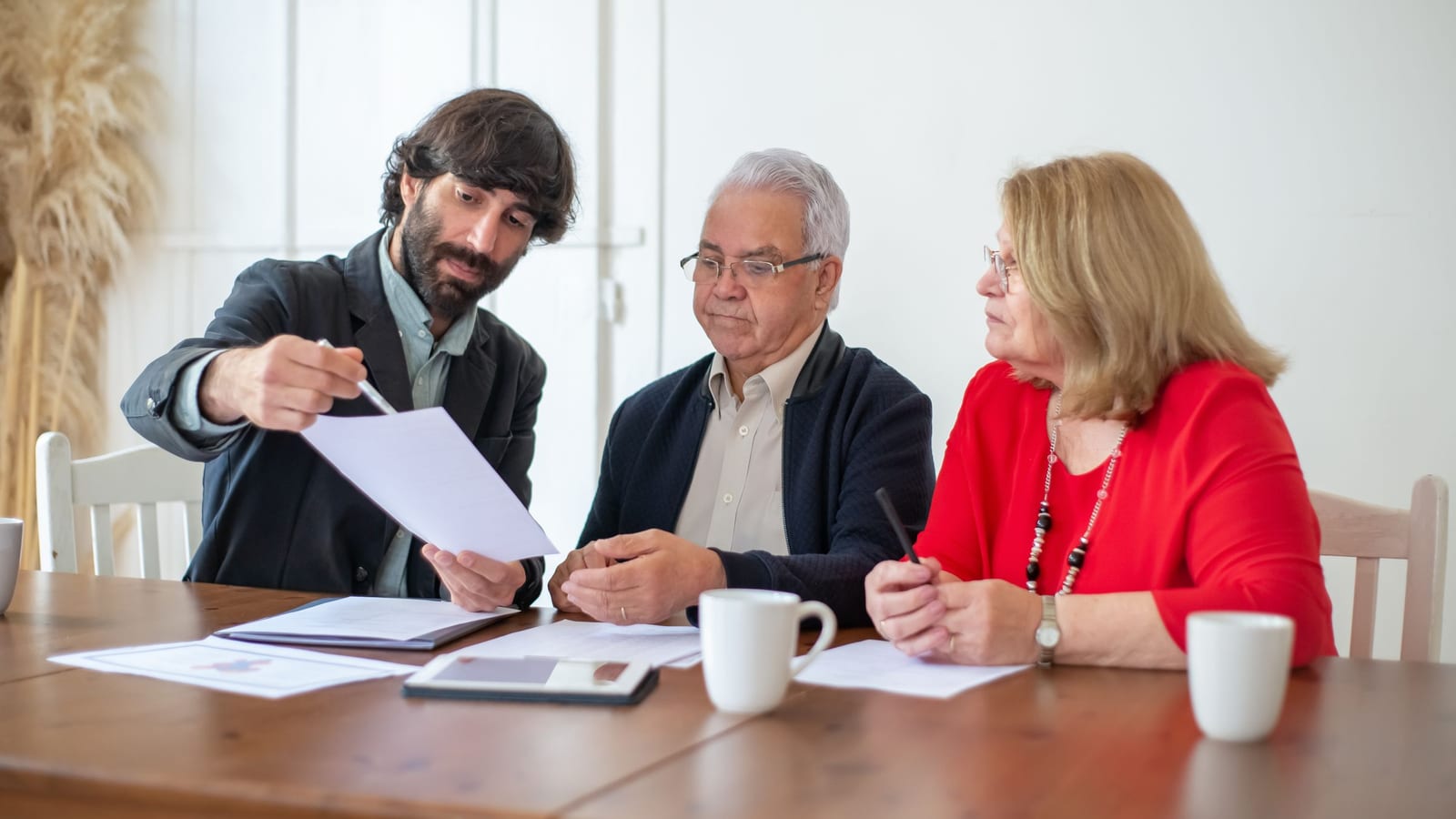 Pareja de adultos mayores revisando los cambios de su plan Medicare para 2027 con una agente de seguros en Florida