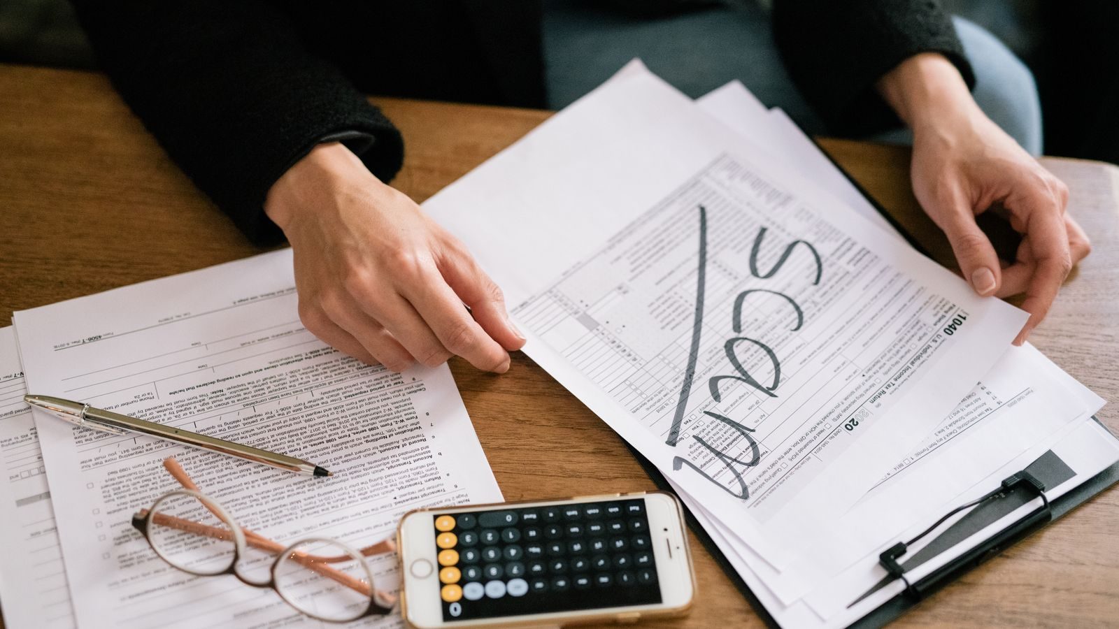 Florida Marketplace enrollee estimating household income for an ACA subsidy application with a calculator and tax documents