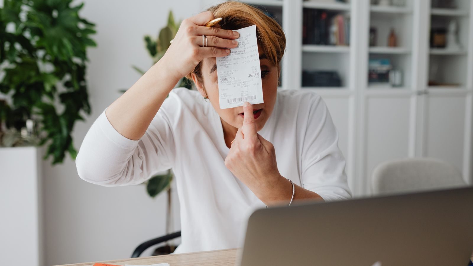 Self-employed Floridian reviewing invoices and income records at a home office desk